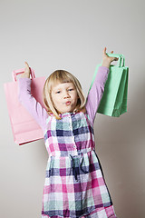 Image showing Little girl with shopping bags and lollipop