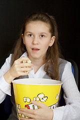 Image showing surprised girl with popcorn on a black background