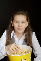 Image showing surprised girl with popcorn on a black background