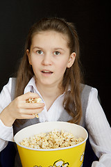 Image showing surprised girl with popcorn on a black background