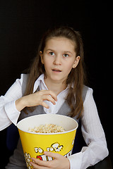 Image showing surprised girl with popcorn on a black background