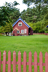 Image showing Wooden colorful house well fence rural homestead 