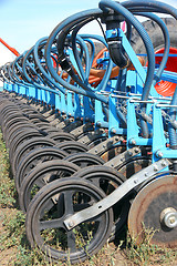 Image showing tractor and seeder planting crops on a field