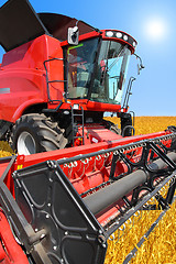 Image showing combine harvester on a wheat field with a blue sky