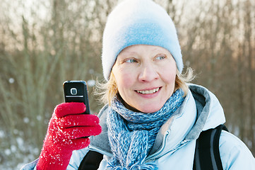 Image showing The woman photographes on a mobile phone in winter on walk