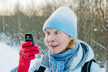 Image showing The woman photographes on a mobile phone in winter on walk