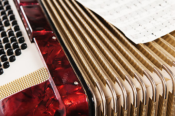 Image showing Red accordion and sheet music, close up