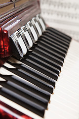 Image showing Red accordion and sheet music, close up