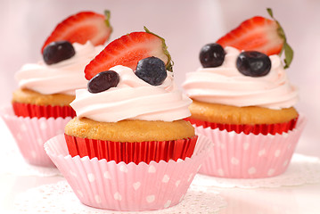 Image showing Vanilla cupcakes with stawberry frosting and strawberries and bl