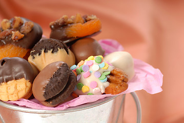 Image showing Silver bucket holding a variety of chocolate covered candies and