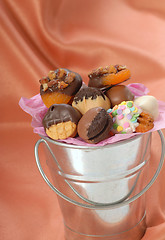 Image showing Silver bucket holding a variety of chocolate covered candies and