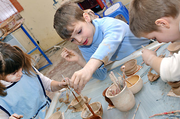 Image showing group of hildren shaping clay in pottery studio
