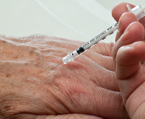 Image showing Injection into hand of senior male