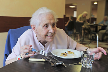 Image showing senior woman eating