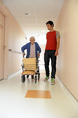 Image showing male nurse and senior woman with walking frame