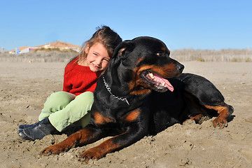 Image showing rottweiler and child on the beach