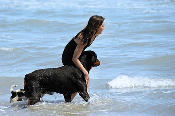 Image showing rottweiler and girl in the sea