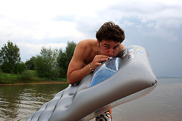 Image showing man blows the air mattress on