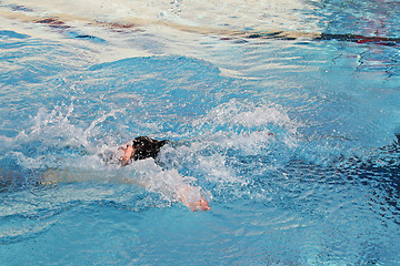 Image showing young man swimming backstroke in water