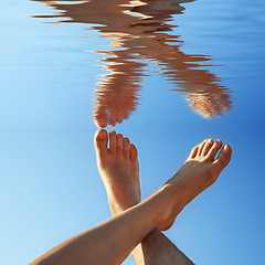 Image showing human legs on the blue water in summer