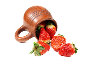 Image showing Ripe strawberry and earthenware mug.