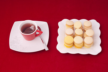 Image showing Cup of tea and stacked and aligned macaroons on a velvet tablecl