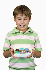 Image showing Child holding yummy cupcakes