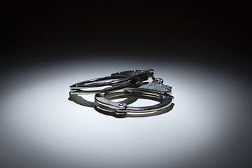 Image showing Abstract Pair of Handcuffs Under Spot Light