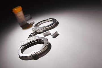 Image showing Handcuffs, Medicine Bottle and Pills Under Spot Light