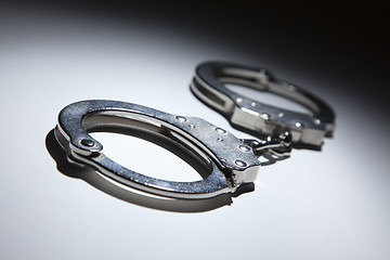 Image showing Abstract Pair of Handcuffs Under Spot Light