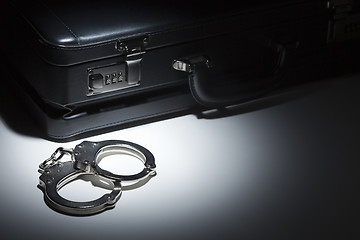 Image showing Pair of Handcuffs and Briefcase Under Spot Light