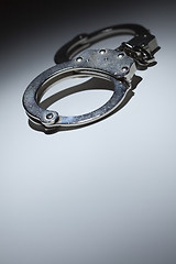 Image showing Abstract Pair of Handcuffs Under Spot Light - Text Room