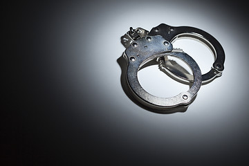 Image showing Abstract Pair of Handcuffs Under Spot Light - Text Room