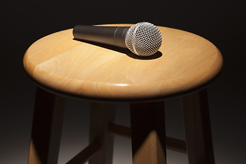 Image showing Microphone Laying on Wooden Stool Under Spotlight