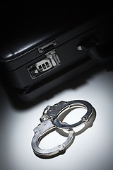 Image showing Pair of Handcuffs and Briefcase Under Spot Light