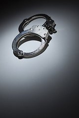 Image showing Abstract Pair of Handcuffs Under Spot Light - Text Room