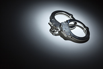 Image showing Abstract Pair of Handcuffs Under Spot Light - Text Room