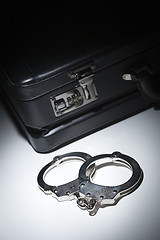 Image showing Pair of Handcuffs and Briefcase Under Spot Light