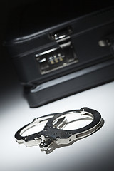 Image showing Pair of Handcuffs and Briefcase Under Spot Light