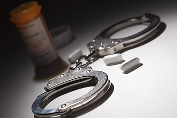Image showing Handcuffs, Medicine Bottle and Pills Under Spot Light