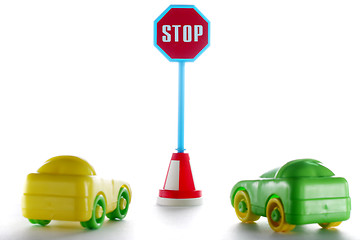 Image showing A couple cars behind stop road sign