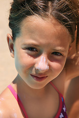 Image showing girl with sunscreen in her nouse 