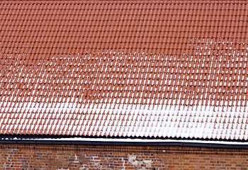 Image showing snow clay tile roof red brick wall backdrop winter 