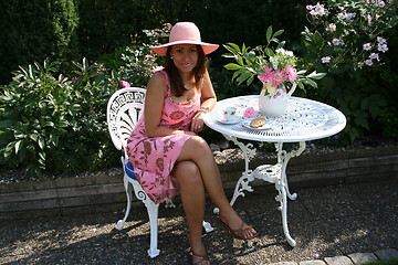 Image showing Lovely view of  beautiful woman sitting in the garden