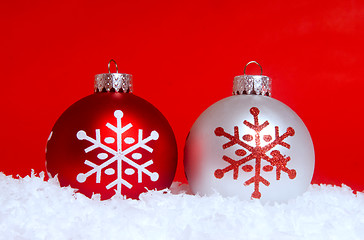 Image showing Two Christmas ornaments in snow