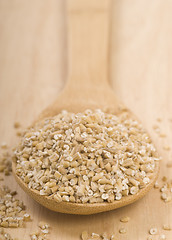 Image showing Steel cut oats on a wooden spoon