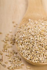 Image showing Steel cut oats on a wooden spoon