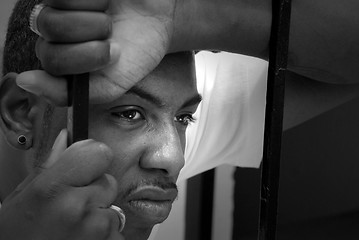 Image showing Face of an angry african american man behind iron bars