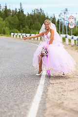 Image showing Bride hitching on a road