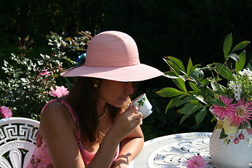 Image showing Coffee-time in garden for a lovely girl in pink hat